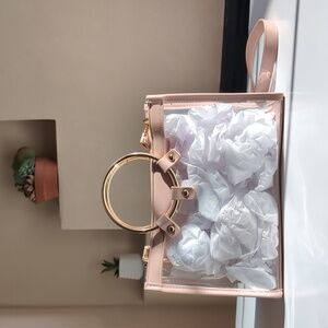 Clear and pink cross body bag with gold colored accessories
